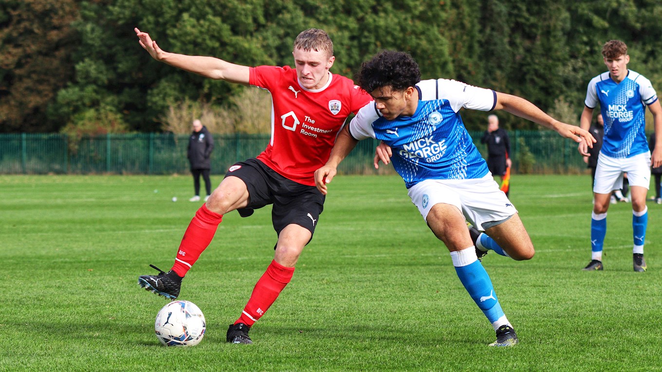 Keegan Hartley holds off a Peterborough United challenge